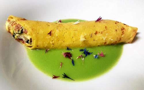 a piece of food on a plate with green sauce at Ciasa Alpina Relax Hotel in Moena