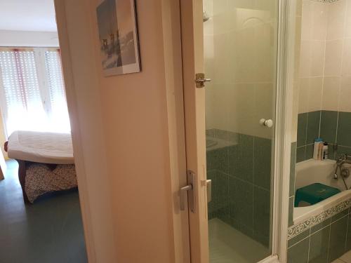 une salle de bain avec une douche avec une porte vitrée dans l'établissement Royan plage, à Royan