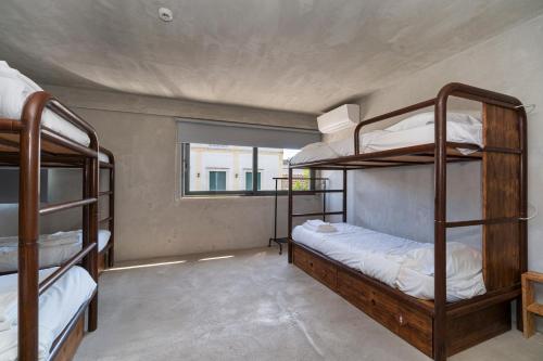 a room with three bunk beds and a window at N1 Hostel Apartments and Suites in Santarém
