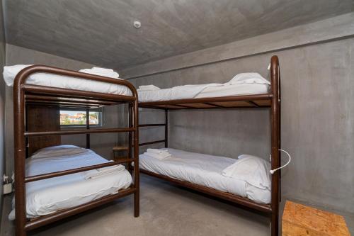 two bunk beds are in a room with a wall at N1 Hostel Apartments and Suites in Santarém