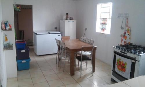 uma cozinha com uma mesa, um fogão e um frigorífico em CHÁCARA SANTA TERESA em Triunfo