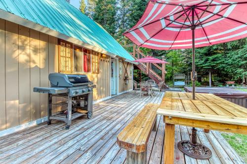 a wooden deck with a grill and an umbrella at Whispering Pines in Leavenworth