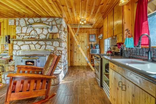 a kitchen with a stone fireplace and a sink at Whispering Pines in Leavenworth