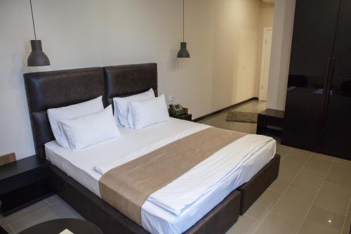 a bedroom with a large bed with white pillows at Hotel Crystal Light in Niš