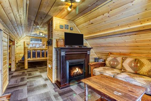 a living room with a fireplace in a log cabin at Whispering Pines in Leavenworth