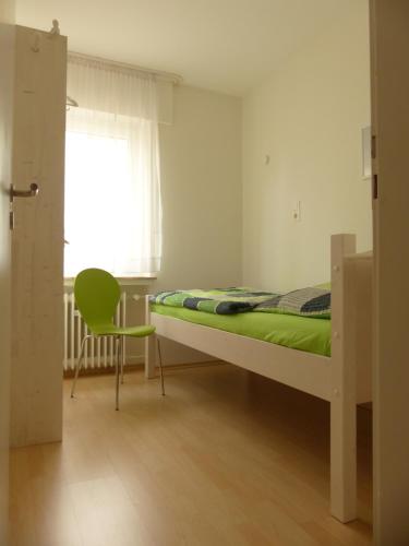 - une chambre avec un lit, une chaise et une fenêtre dans l'établissement Ferienwohnung Asenberg, à Bad Salzuflen