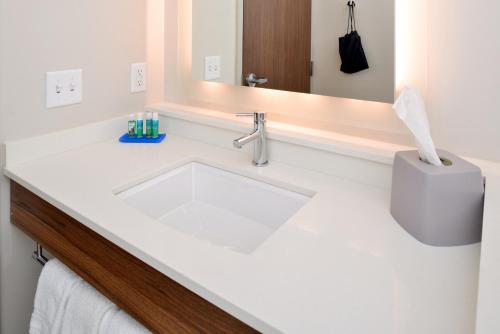 Baño blanco con lavabo y espejo en Holiday Inn Express & Suites - Ottumwa, an IHG Hotel, en Ottumwa