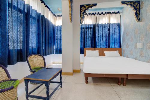 Schlafzimmer mit einem Bett, einem Tisch und Stühlen in der Unterkunft Island Tower Guest house in Udaipur