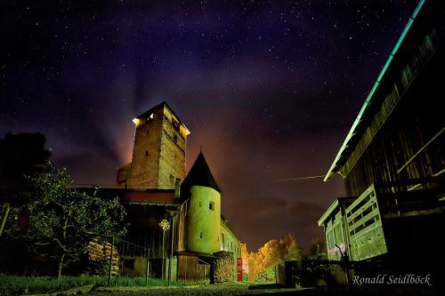 an old building with a tower at night at Hotel Bruggner Stub`n in Landeck