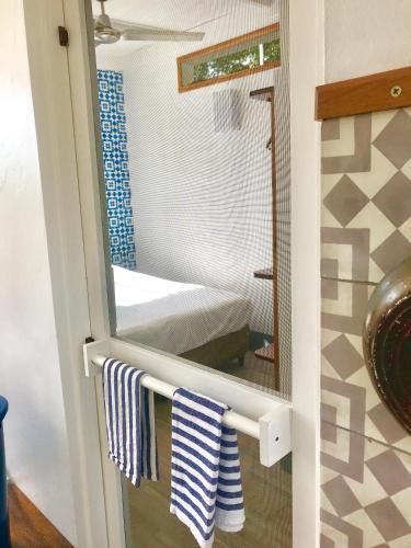a bathroom with a mirror and a bed in a room at Oleadas Maderas in San Juan del Sur