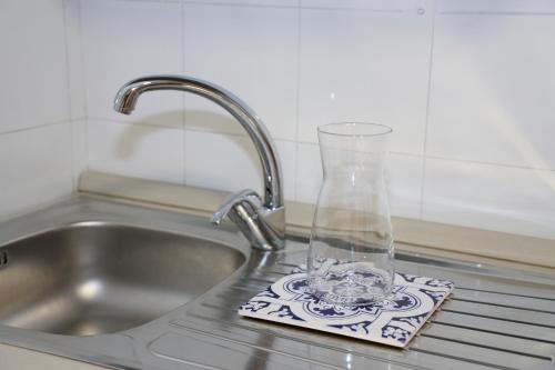 um lavatório de cozinha com um vaso de vidro numa base para copos em Neri 1 em Florença