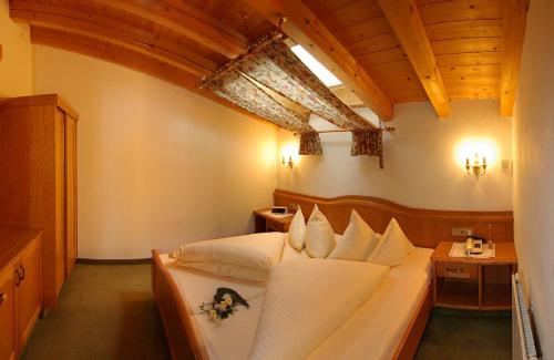a bedroom with a large bed with white pillows at Appartement Frühstückspension Landhaus Karwendel in Pertisau