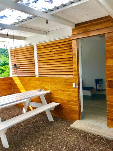 a white picnic table in front of a wooden wall at Oleadas Maderas in San Juan del Sur