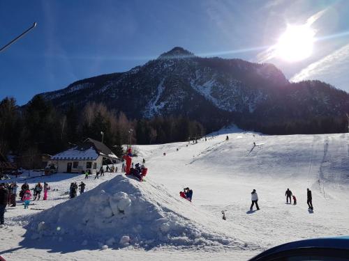 a group of people skiing down a snow covered mountain at SavaDolinka House in Mojstrana
