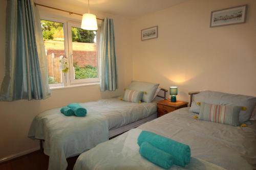 a bedroom with two beds and a window at Cowsley House in Derby