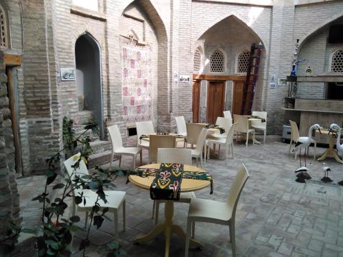 a restaurant with tables and chairs in a building at Aist House in Bukhara