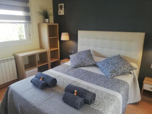 a bedroom with a bed with blue pillows on it at LOFT A 20' DE BARCELONA Y 7' DE LA UAB. in Barbera del Valles