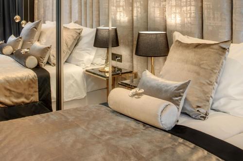 a bedroom with two beds with pillows and a mirror at Posh Residence Luxury Suites in Split