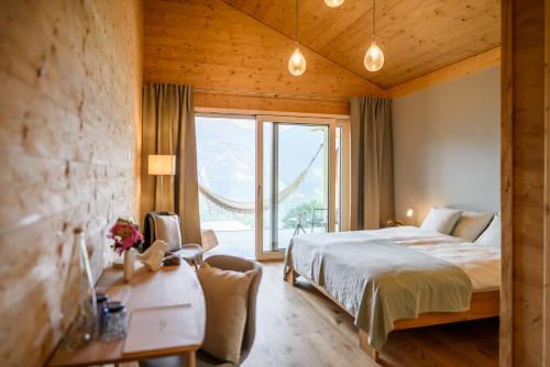 a bedroom with a bed and a large window at Chalet Diognysos B&B in Crans-Montana