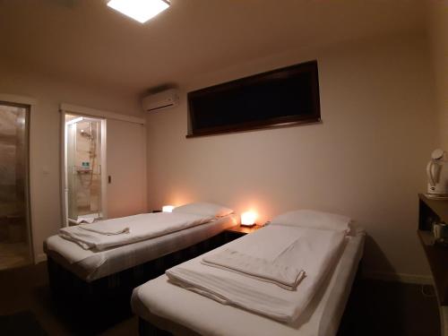 two beds in a room with a tv on the wall at A7 Apartments in Komárno