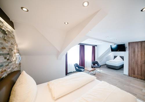 a bedroom with a bed and a living room at Central City Hotel in Füssen