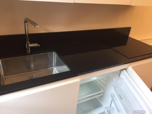 a kitchen counter with a sink and an empty refrigerator at San Marco square apartament in Venice
