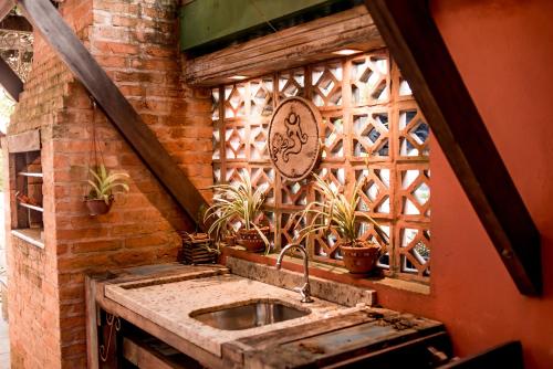 a kitchen with a sink in a brick wall at Morada Canto Norte - Apartamentos Beira Mar in Garopaba