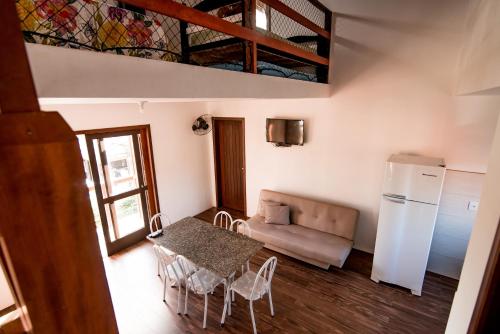 a kitchen and dining room with a table and a refrigerator at Morada Canto Norte - Apartamentos Beira Mar in Garopaba