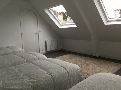 an attic bedroom with two beds and two skylights at Maison familiale Groix in Groix