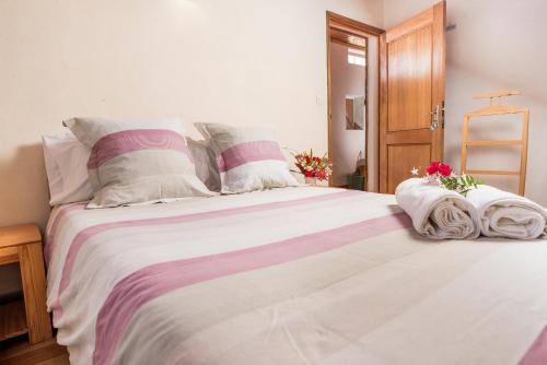 a bedroom with a large white bed with flowers on it at Villa ChezSoa, Antananarivo in Antananarivo