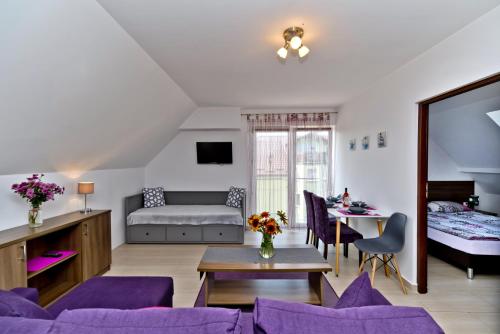 1 dormitorio y sala de estar con muebles de color púrpura. en Willa Aura Mare en Władysławowo