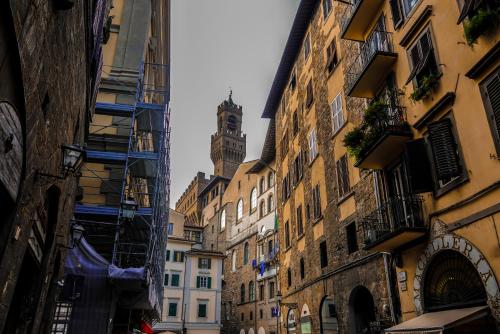 uma rua da cidade com edifícios e uma torre do relógio em Neri 1 em Florença