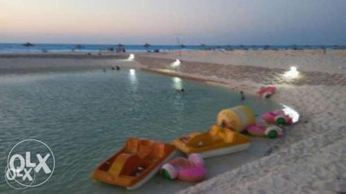 a beach with a group of toys in the water at شاليه عايدة بيتش للعائلات فقط in El Alamein