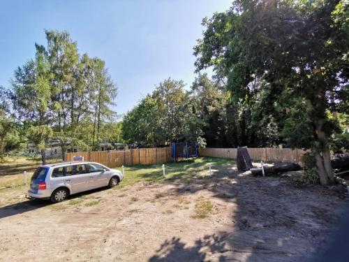 a car parked in a yard next to a fence at Bungalows am Grimnitzsee in Joachimsthal