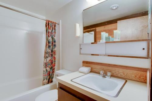 a bathroom with a sink and a mirror and a tub at 21 Pole House Lane in Sunriver