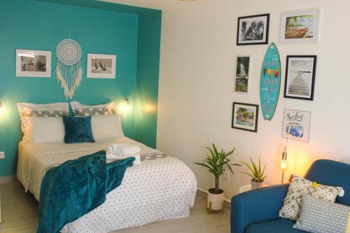 een slaapkamer met een bed en een blauwe muur bij COLIBRIS PARADISE LA MARINA in Le Gosier