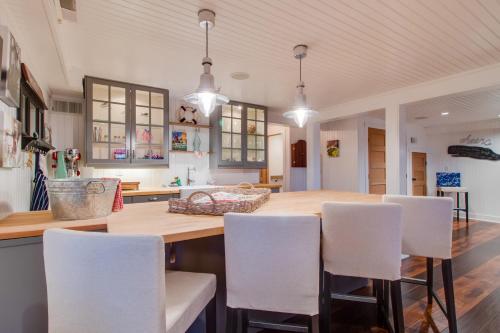 a kitchen with a wooden table and white chairs at South Hampton House in Tolovana Park