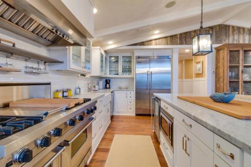 a large kitchen with white cabinets and a refrigerator at South Hampton House in Tolovana Park