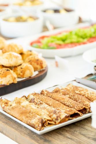 a table topped with different types of food on plates at Deniz Kabugu Hotel in Alacati