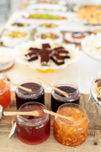 a table with several jars of jam and a plate of food at Deniz Kabugu Hotel in Alacati