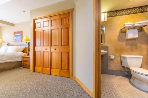 a bathroom with a bed and a toilet and a sink at Slopeside in Big Sky in Big Sky Mountain Village