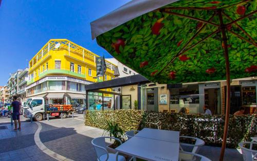 a restaurant with tables and chairs and a yellow building at Lar dois coracões in Lisbon
