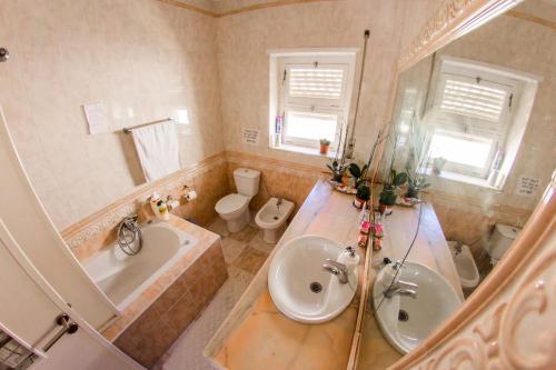 a bathroom with a sink and a tub and a toilet at Lar dois coracões in Lisbon