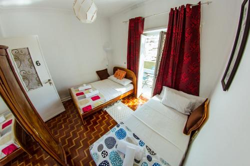 um pequeno quarto com 2 camas e uma janela em Lar dois coracões em Lisboa