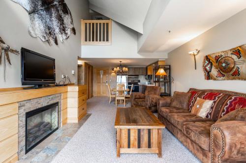 a living room with a couch and a fireplace at Shoshone 1986 in Big Sky