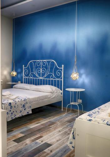 a blue bedroom with a bed and a table at La terrazza dei colori in Gaeta