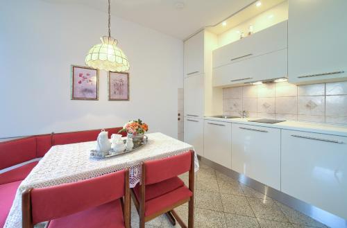 a kitchen with a table and red chairs at Apartment Punat in Punat