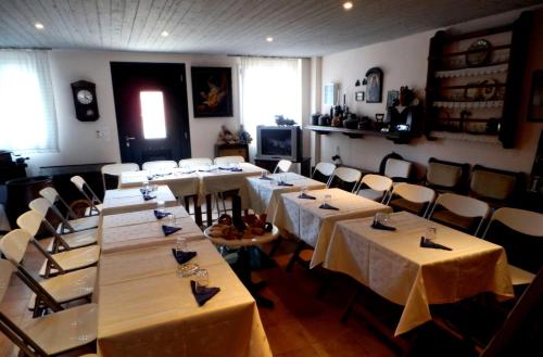 a dining room with tables and chairs with white tablecloths at Irides in Souvala