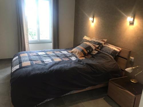 1 cama grande en un dormitorio con ventana en l’appartement du Plateau d’Hauteville, en Hauteville-Lompnes