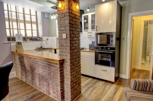 a kitchen with a brick wall in the middle of a room at The Old Joiner's Shop in Whitby
